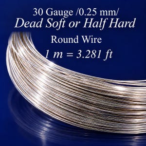 Może przedstawiać: Szpula błyszczącego, srebrnego okrągłego drutu. Tekst na obrazie brzmi: 30 Gauge /0.25 mm/ Dead Soft or Half Hard Round Wire 1 m = 3.281 ft. Drut jest cienki i metaliczny, ułożony w okrągły zwój na ciemnoniebieskim tle.