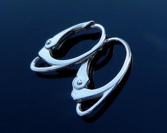 May include: A pair of silver hoop earrings with a clip-on closure. The earrings are made of a smooth, shiny metal.
