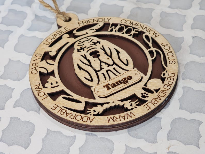 May include: A wooden ornament shaped like a dog with the words "Woof" and "Tango" on it. The ornament is decorated with the words "caring, loyal, lovable, friendly, companion, joyous, dependable, warm, adorable".