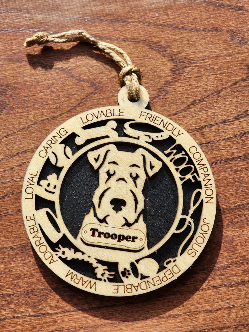 May include: A wooden ornament shaped like a dog with the name "Trooper" on a tag. The ornament is decorated with words describing a dog's personality, such as "Loyal", "Caring", "Friendly", and "Dependable".