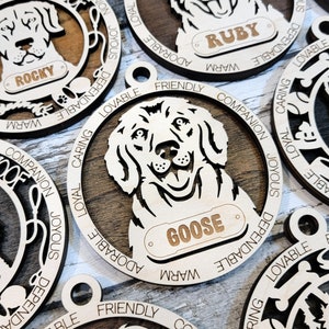 May include: Wooden dog ornaments with personalized names, including Rocky, Ruby, and Goose. Each ornament features a dog breed silhouette with a descriptive word circle around the dog. Words include: "Woof", "Loyal", "Caring", "Friendly", "Companion", "Joyous", "Dependable", "Lovable", "Adorable", and "Warm".
