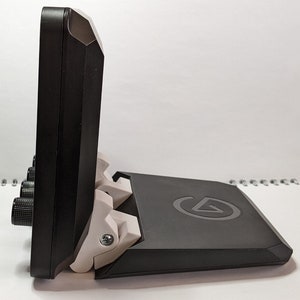 Puede incluir: Un monitor negro con un soporte blanco y un logotipo blanco en el soporte. El monitor tiene un bisel negro y un bot&oacute;n blanco en el lateral.