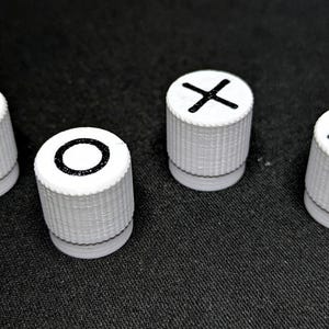 May include: Four white plastic knobs with black symbols on top. The symbols are a triangle, a circle, an X, and a square.