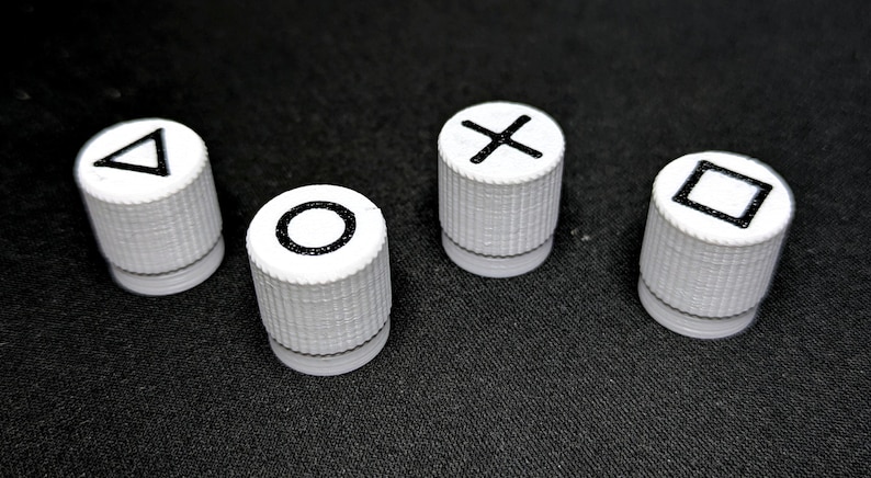 May include: Four white plastic knobs with black symbols on top. The symbols are a triangle, a circle, an X, and a square.
