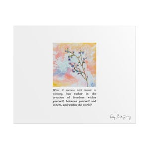 May include: A white art print featuring a square painting of a delicate sprig with small blue flowers against a soft yellow, orange, and white abstract background. Below the painting is the text: What if success isn't found in winning, but rather in the creation of freedom within yourself, between yourself and others, and within the world? A signature is in the bottom right.