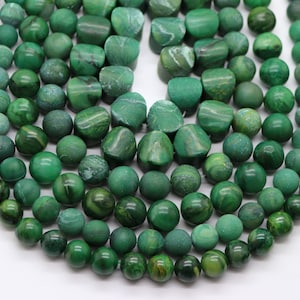 May include: A strand of green gemstone beads, some round and some irregularly shaped, with a mottled pattern.