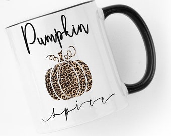 May include: White ceramic mug with a black rim and handle. The mug has a black and brown leopard print pumpkin design with the text "Pumpkin Spice" in black cursive.