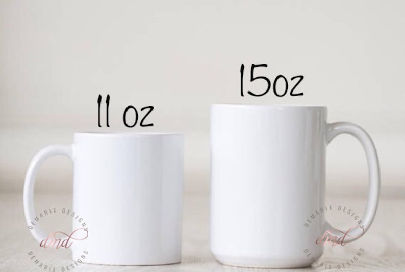 May include: Two white ceramic mugs, one labeled "11 oz" and the other "15 oz". Both mugs have a simple, clean design with a curved handle. The mugs are set against a plain background, highlighting their shape and size.