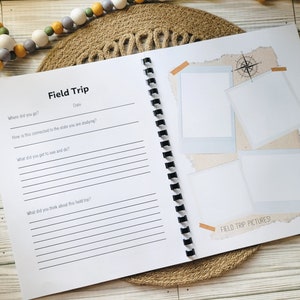 May include: A white field trip journal with a black spiral binding. The journal has a section for writing notes and a section for photos. The text on the cover reads "Field Trip" and "Field Trip Pictures!"