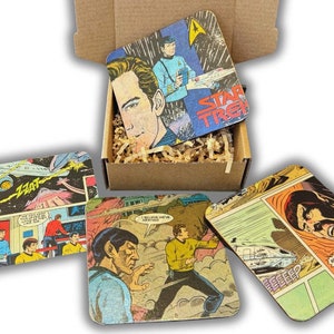 Könnte beinhalten: Ein Set aus vier quadratischen Untersetzern mit Vintage-Star-Trek-Comic-Illustrationen. Die Untersetzer befinden sich in einem Karton mit Verpackungsmaterial. Sie zeigen Bilder von Captain Kirk, Spock und anderen Charakteren.