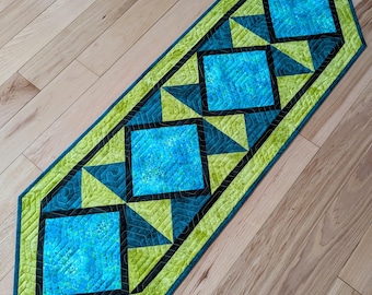 Caminho de mesa acolchoado em tons de verde-azulado e verde-limão, decoração vibrante para casa.