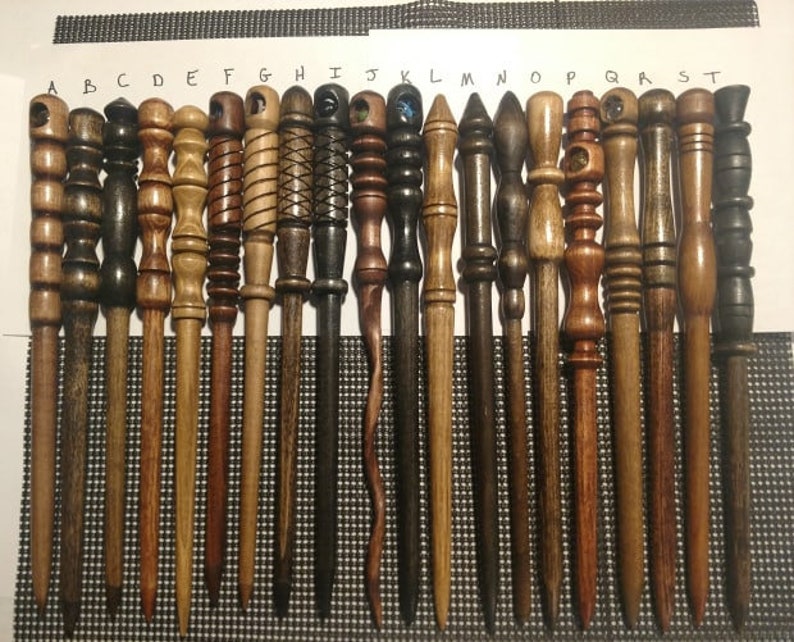 Pu&ograve; includere: Un set di 19 bacchette di legno con vari disegni e finiture. Le bacchette sono disposte in fila, con le punte rivolte a destra. Le bacchette sono realizzate in diversi tipi di legno, tra cui legno scuro, legno chiaro e legno con una finitura naturale. Alcune delle bacchette hanno elementi decorativi, come un design a spirale o un nodo all'estremit&agrave;.