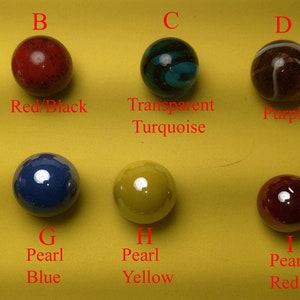 Pu&ograve; includere: Dieci biglie di diversi colori e motivi, etichettate dalla A alla J. Le biglie sono disposte in due file di cinque. Le biglie sono tutte pi&ugrave; o meno della stessa dimensione e hanno un diametro di circa 2,5 cm.