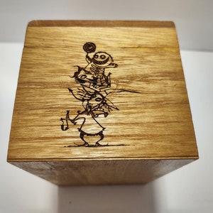 May include: A wooden box with a laser-engraved image of three characters from the movie "The Nightmare Before Christmas". The characters are Jack Skellington, Sally, and Oogie Boogie.