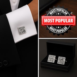 Puede incluir: Un par de gemelos cuadrados de tono plateado con un diseño de código QR en blanco y negro. Un gemelo se muestra sujeto a un puño de camisa blanco, mientras que ambos se presentan dentro de una caja rectangular negra con forro de terciopelo.