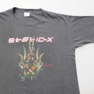 May include: Gray t-shirt with a graphic of a hand holding a variety of tools and the text "STATIC-X" and "machine" printed on the front.