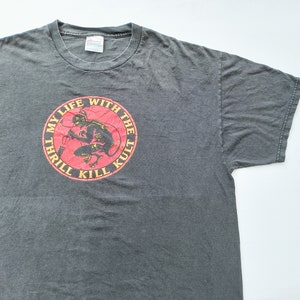 May include: A dark gray t-shirt with a red circle graphic featuring a black devil-like figure and the text "My Life With The Kult Thrill Kill".
