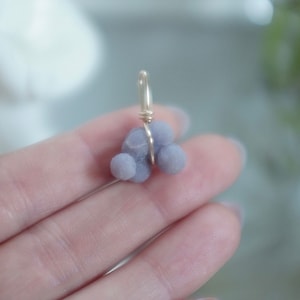 May include: A purple agate pendant with a gold wire wrap. The agate is a cluster of small, round stones.