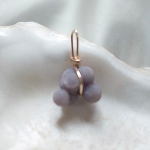 May include: A purple agate pendant with a gold wire wrap. The agate is a cluster of small, rounded stones.