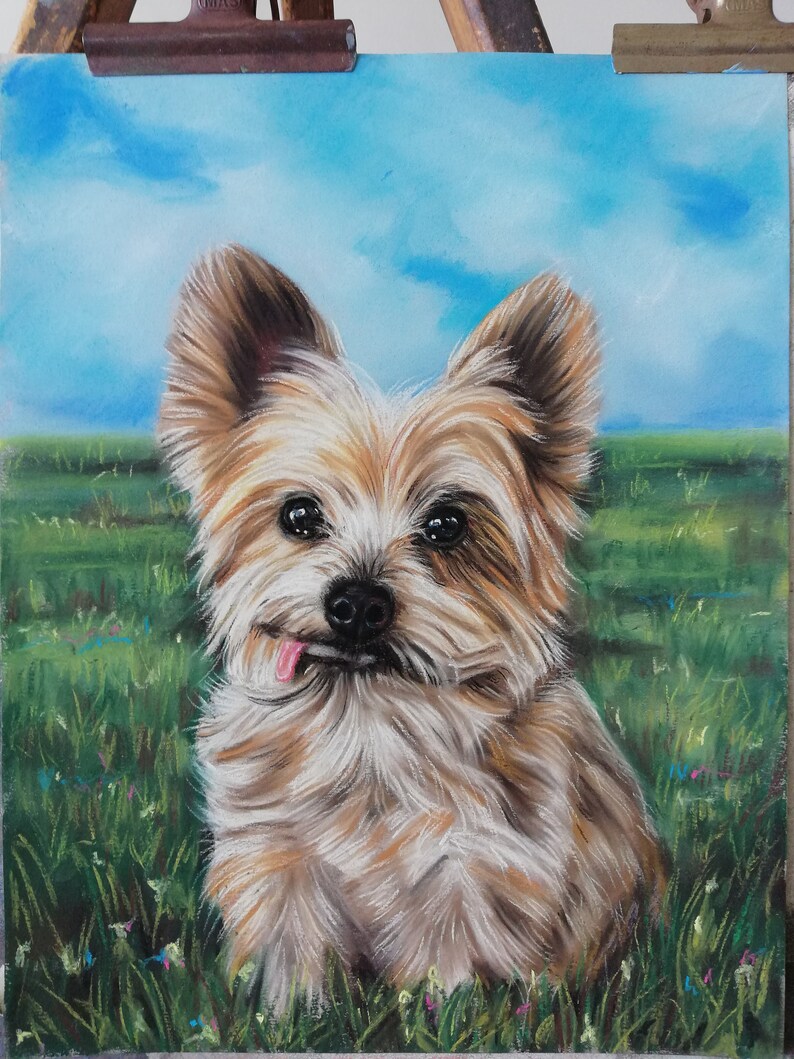 May include: A painting of a small, brown and white dog with its tongue sticking out. The dog is sitting in a field of green grass with blue sky in the background.