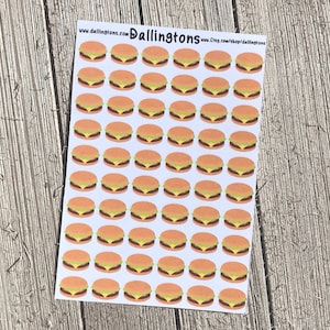 Puede incluir: Una hoja de 49 etiquetas adhesivas blancas con una imagen de dibujos animados de una hamburguesa en cada etiqueta. Las hamburguesas son amarillas, marrones y verdes.