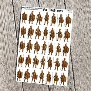 May include: Sheet of stickers featuring illustrations of Roman soldiers in full armor, holding spears and shields. The stickers are in shades of brown, gold, and bronze, with details like helmets and swords. The sheet has the text "Dallingtons 1020".