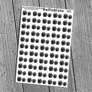 May include: Sheet of black gemstone stickers with a faceted design. The stickers are arranged in pairs and are on a white background. The sheet has the text "Dallingtons 865" at the top. The background is a wooden surface.