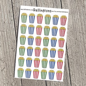 Puede incluir: Hoja de pegatinas con palomitas de maíz en recipientes a rayas. Los recipientes son de color verde, azul y rojo. Las palomitas son amarillas. Las pegatinas están sobre un fondo blanco. La dirección del sitio web www.dallingtons.com es visible.