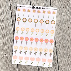 Puede incluir: Una hoja de pegatinas con varios diseños de flores en rosa, amarillo y verde. Las pegatinas están dispuestas en filas e incluyen diferentes formas y tamaños de flores. El texto "www.dallington.com Dallington.com Etsy.com/shop/dallington" está impreso en la parte superior de la hoja.