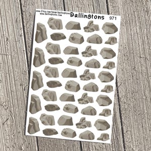 May include: A sheet of stickers featuring various gray rock illustrations. The stickers are in different shapes and sizes, with shading to give a 3D effect. The sheet has the text "Dallington's" and the number "971".