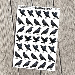 May include: Sheet of black crow stickers in various poses, including perched and flying. The stickers are on a white background with the text "Dallingtons 1010" at the top. The background is a light brown wooden surface.