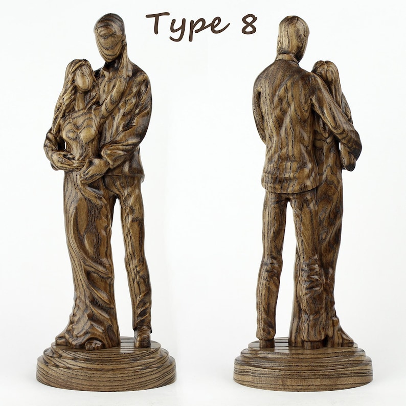 May include: A wooden sculpture of a couple embracing, with the man holding the woman close. The sculpture is made of dark wood with a natural grain pattern. The sculpture is labelled "Type 8".