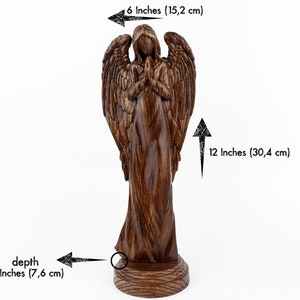 May include: A wooden angel figurine with wings outstretched, standing on a round base. The angel is carved with intricate details and has a prayerful pose. The figurine is 12 inches tall, 6 inches wide, and 3 inches deep.