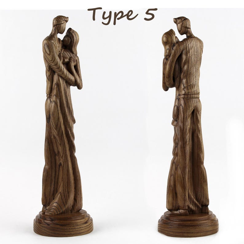 May include: A wooden sculpture of a couple embracing, carved in a realistic style. The sculpture is made of dark brown wood and has a natural wood finish. The couple are standing on a wooden base.