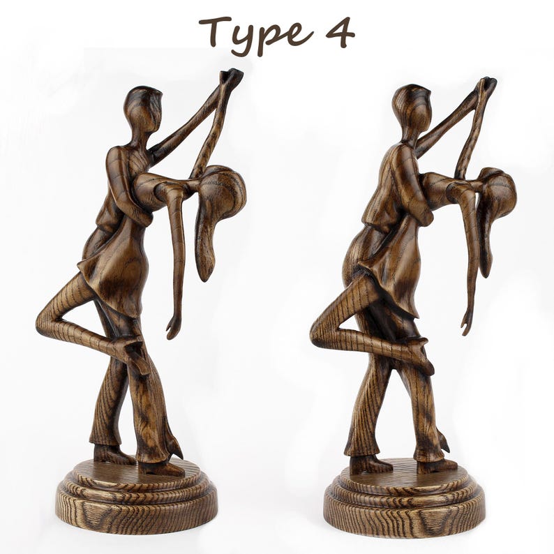 May include: A wooden sculpture of a couple dancing. The man is holding the woman in a dip. The sculpture is painted in a dark brown colour. The sculpture is on a wooden base. Type 4.