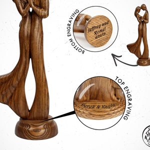 May include: A wooden sculpture of a couple dancing, with the words "Jeffrey and Romel 6/22/19" engraved on the bottom and "Derek & Ragle" engraved on the top. The sculpture is made by "Wood Soul" and is handmade.
