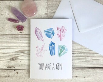 May include: A white card with a watercolour illustration of colourful gemstones and the text "You are a gem".