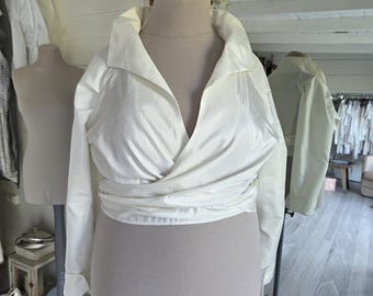 Bolero cruzado drapeado en tafetán sintético o seda dupioni, manga larga o tres cuartos, cuello alto pequeño, talla ajustable M-L o XL-2XL.