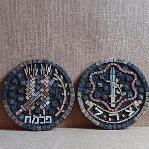 May include: Two round mosaic wall art pieces with black backgrounds. The left piece features a stylized design of a tree with a Hebrew inscription that reads "Jerusalem". The right piece features a stylized design of a sword and a star with a Hebrew inscription that reads "The City".