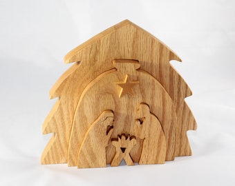 May include: Wooden nativity scene featuring a tree-shaped structure with layered cutouts. The scene includes figures of Mary, Joseph, and baby Jesus, with a star above. The wood has a natural, light brown color.