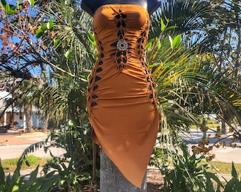 May include: A rust-colored strapless dress with cutouts and a geometric design. The dress is made of a stretchy fabric and has a fitted silhouette.