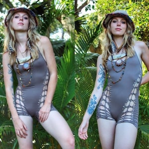 May include: A woman wearing a brown crocheted bodysuit with cutouts and a brown crocheted hat. She is wearing multiple necklaces with beads and charms. She has a tiger tattoo on her arm.