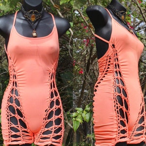 May include: A coral-coloured sleeveless top with a crocheted design on the sides. The top is fitted and has a scoop neck.