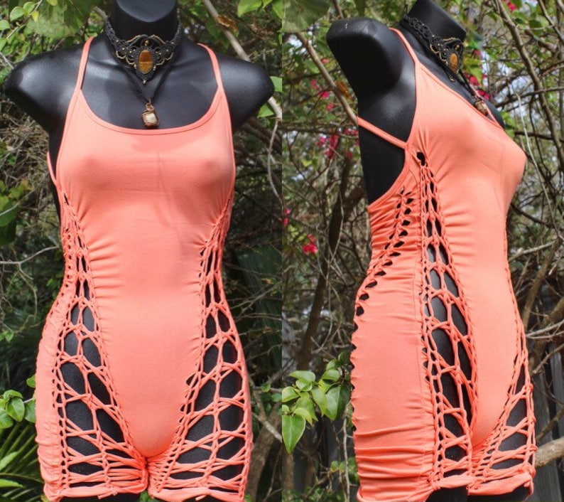 May include: A coral-coloured sleeveless top with a crocheted design on the sides. The top is fitted and has a scoop neck.