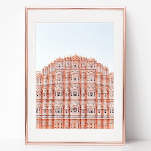 May include: A photograph of the Hawa Mahal, a palace in Jaipur, India. The palace is made of pink sandstone and has a unique honeycomb design with many windows.