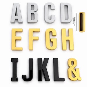 May include: A collection of metallic alphabet letters and an ampersand. The letters are in silver, gold, and black. The height of the letter I is 30mm, or approximately 1.2 inches.