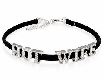以下が含まれることがあります： HOT WIFEという文字を形作るシルバーカラーの金属製文字が付いた黒いベルベットのチョーカーネックレス。各文字には小さな透明なラインストーンが埋め込まれています。ネックレスには、シルバーカラーの金属製延長チェーンとロブスタークラスプが付いています。