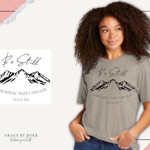 May include: A grey t-shirt with a black mountain graphic and the text "Be Still and Know That I Am God, Psalm 46:10".
