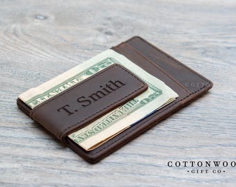 May include: A brown leather wallet with a money clip and the name "T. Smith" embossed on the front. The wallet is open and has cash inside.