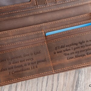 May include: A brown leather wallet with multiple card slots and a bill compartment. The wallet has stitched edges and includes engraved text from 1 Corinthians 13:4 and a personal message. A blue card is visible inside.